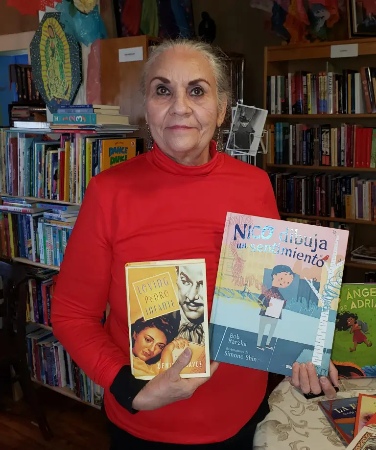 Denise Chavez holding a couple of her books