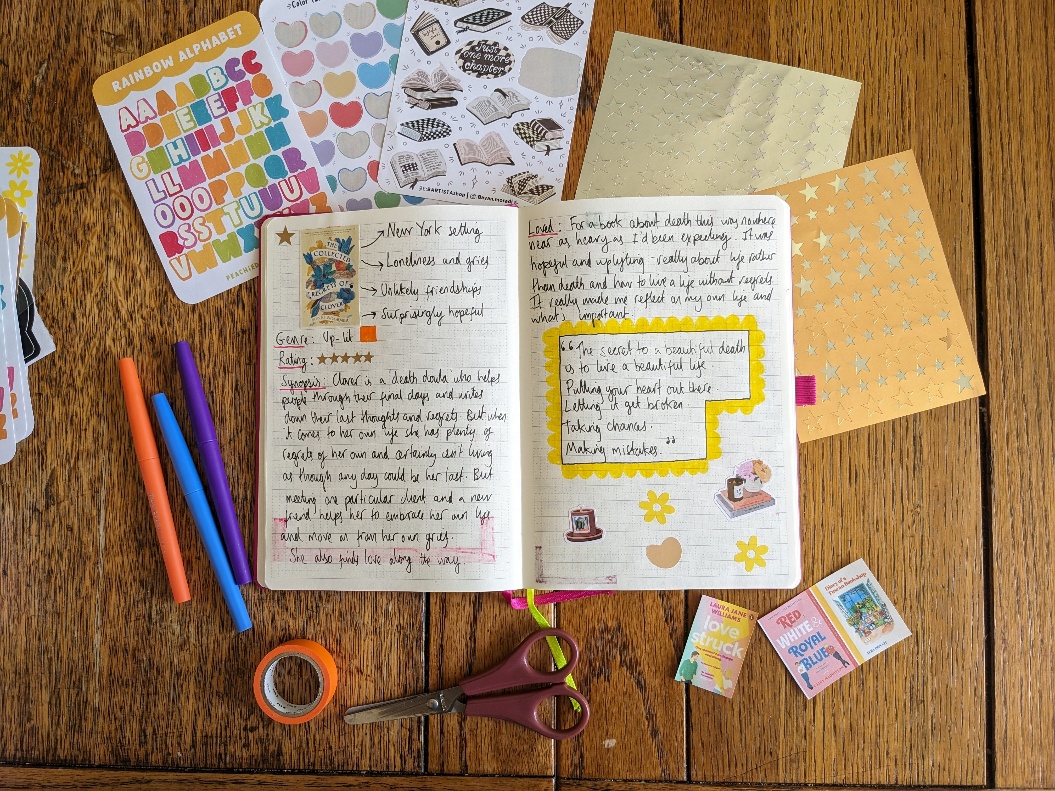 A flat lay shot of a reading journal and other art supplies